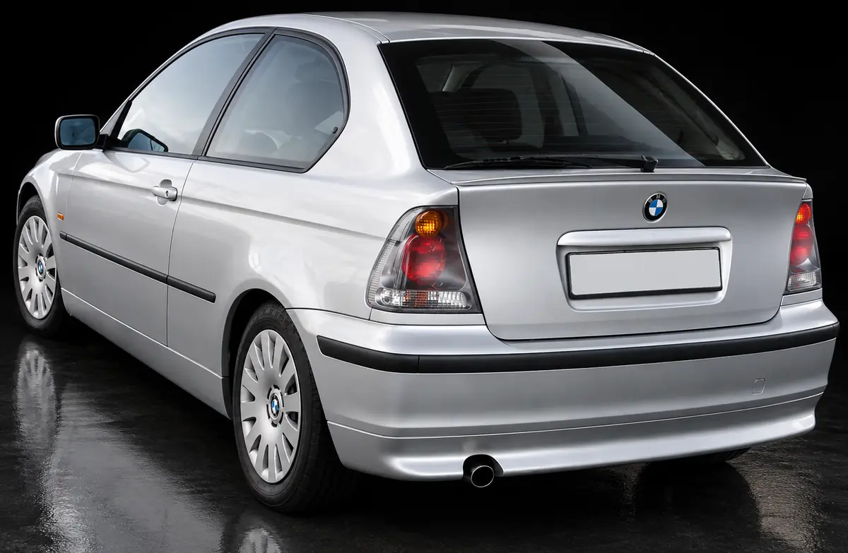 KI-Illustration eines silbernen E46 Compact, schräg von hinten, mit dem Serien-Heckstoßfänger und einem einzelnen Endrohr